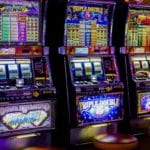 Trois machines à sous lumineuses dans un casino.