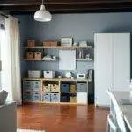 Salon moderne avec étagères et bureau.