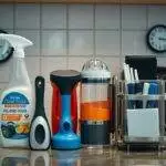 Produits de nettoyage et ustensiles de cuisine sur comptoir.