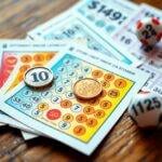 Cartons et boules de bingo sur table en bois.