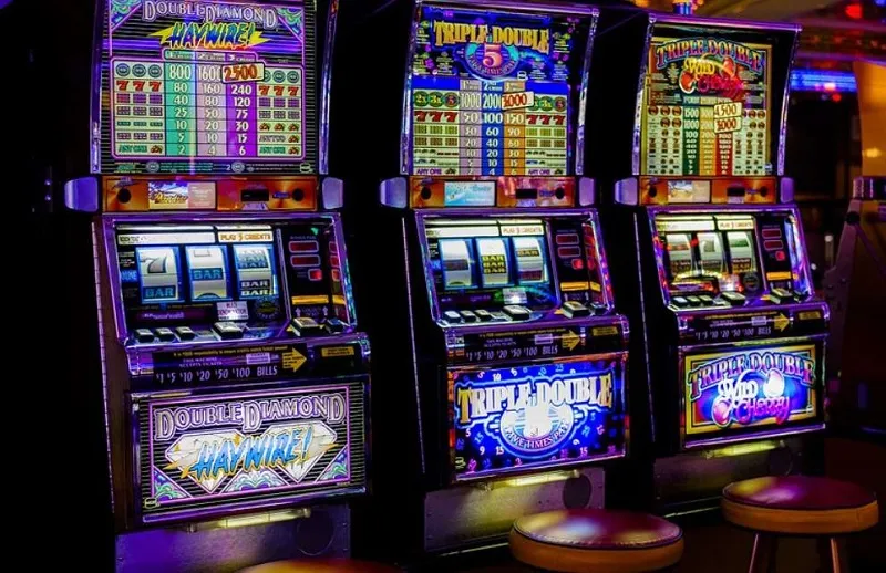 Trois machines à sous lumineuses dans un casino.